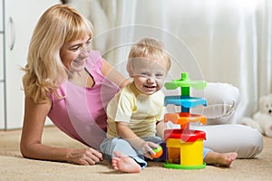 Mother and her child playing with colorful logical toy