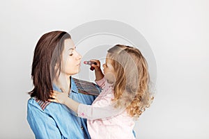 Mother and her child daughter girl with a lipstick. Portrait of