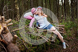 Mother and her child girl playing and having fun together on walk in forest outdoors. Happy loving family posing on nature