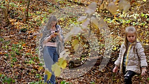 Mother and her child girl playing together on autumn walk in nature outdoors