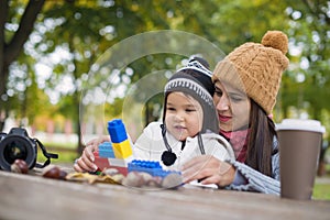 Mother with her child play in park playing with blocks