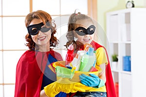 Mother and her child in Superhero costumes. Mom and kid ready to house cleaning. Housework and housekeeping.
