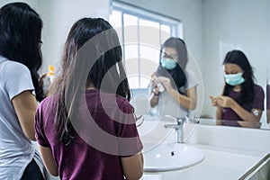 Mother and her child washing hands with soap