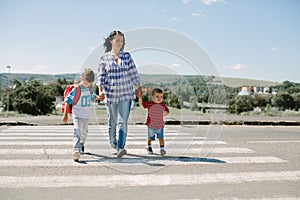 Mother and her children crossing road