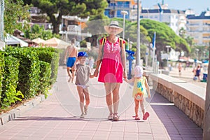 Mother with her children go to sea beach during tropical rest