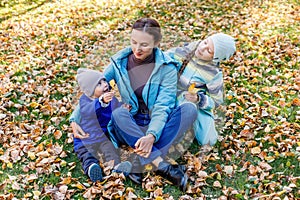 Mother and her children having fun in autumn park