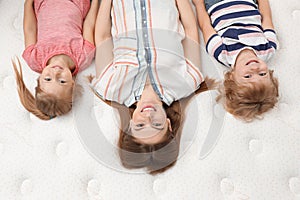 Mother and her children lying on new orthopedic mattress