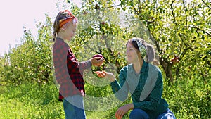 A mother and her children picking apples in a beautiful, rustic orchard