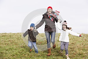 Mother And Her Children Running In The Park