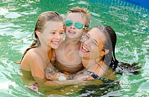 Mother and her children in the swiming pool