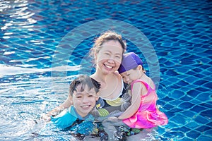 Mother with her children in swimming pool