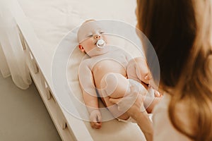 Mother and her cute baby on the bed, baby massage