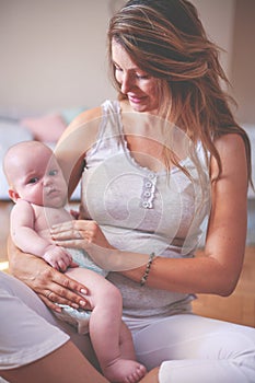 Mother and her cute baby at home. Mother holding little baby in