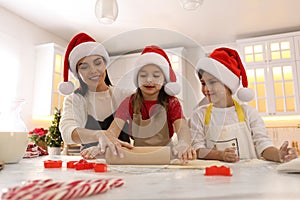 Mother and her cute little children making Christmas cookies in kitchen