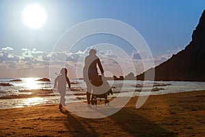 Mother with her daughter and baby on a sandy beach