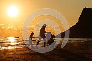 Mother with her daughter and baby on a sandy beach