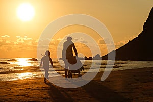 Mother with her daughter and baby on a sandy beach