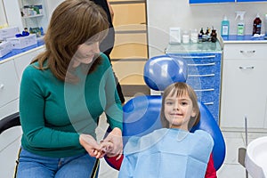 A mother with her daughter at the dentistÃ¢â¬â¢s. The mother is holding her daughter on her hand photo