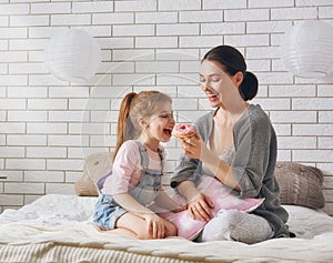 Mother and her daughter eating donuts