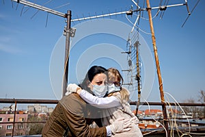 Mother with her daughter have medical gloves and masks, they are worry