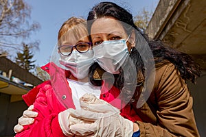 Mother with her daughter have medical gloves and masks, they are worry