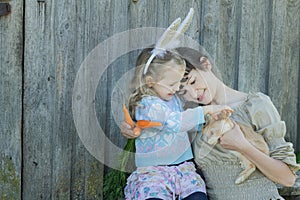 Mother and her daughter holding adorable little Easter rabbit