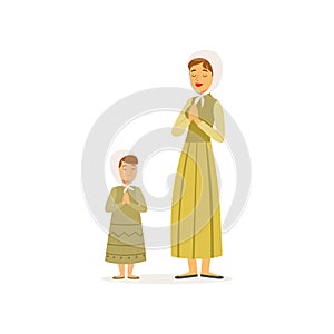 Mother with her daughter prays to the Lord. Woman and little girl in long dresses and headscarves. Religious family