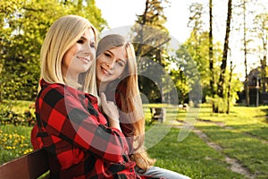 Mother with her daughter spending time together in park on sunny day