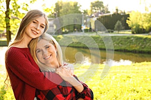 Mother with her daughter spending time together in park on sunny day