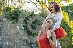 Mother with her daughter in a walk in the autumn park