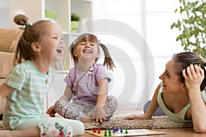 Mother and her daughters playing in board game