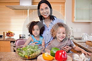 Mother and her daughters preparing salad photo