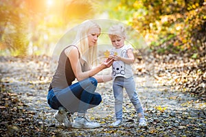 Mother and her daugther in autumn at park - family photo