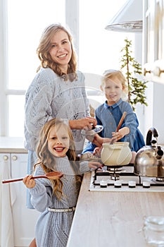 Mother with her kids cooking in the kitchen to xmas