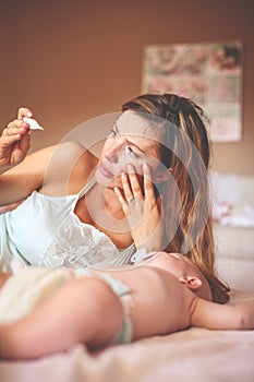 Mother with her little baby boy at home. Worried mother checks