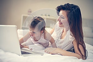 Mother and her little baby at home. Mother with her baby using l