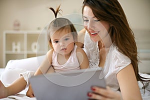 Mother and her little baby at home. Mother with her baby using t