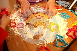 Mother and her little baby making hands cookies at home in the kitchen