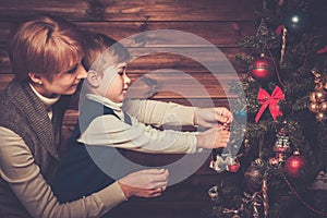 Mother and her little boy decorating christmas tree