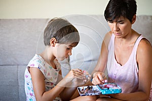 Mother and her little daughter doing make up for each other