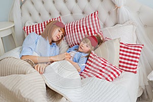 Mother and her little daughter sleep on a bed