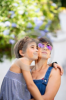 Mother and her little daughter traveling together in urban background.