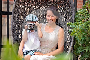 Mother and her little son with retro camera