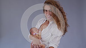 Mother and her Newborn Baby. Happy Mother holding her New born Baby girl kissing and hugging. Maternity concept