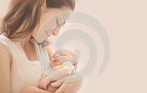 Mother and her Newborn Baby together. Love. Happy Mother and Baby kissing and hugging. Soft image of Beautiful Family. Maternity