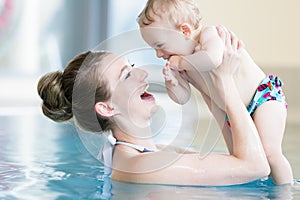 Mother and her newborn child at infant swimming class