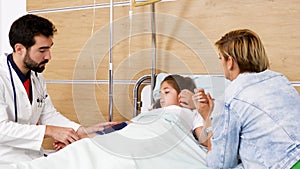Mother with her sick daughter laying in the bed in hospital