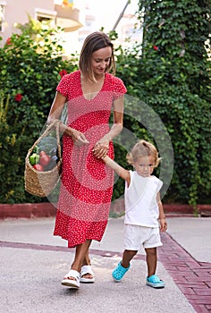 mother and her son with a basket of fruits and vegetables from farmers market