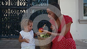 mother and her son with a basket of fruits and vegetables from farmers market