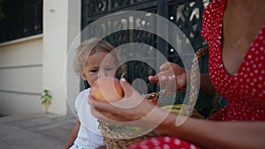 mother and her son with a basket of fruits and vegetables from farmers market